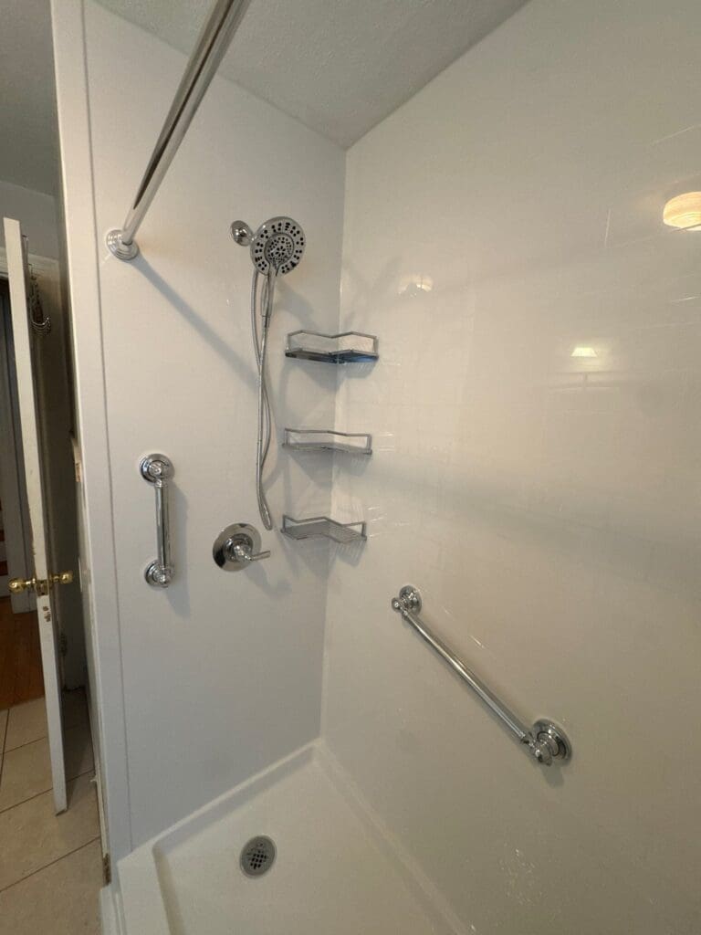 A modern, beautifully tiled walk-in shower with a frameless glass door, completed by an MA shower remodel contractor.