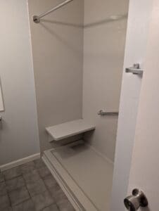 A modern, beautifully tiled walk-in shower with a glass door, which replaced an old bathtub in a Worcester, MA, home.
