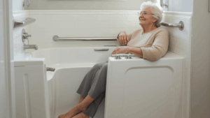 Senior woman smiling comfortably inside a newly installed white walk-in bathtub with safety grab bars